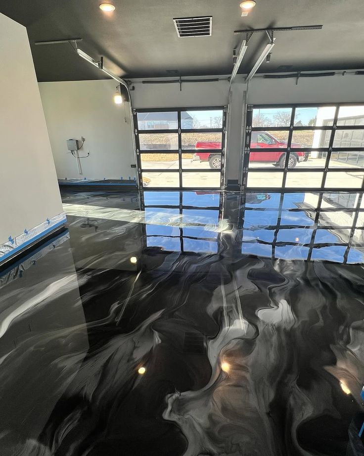 Rendu effet Flow : sol de garage en résine époxy noir veiné de blanc, finition miroir