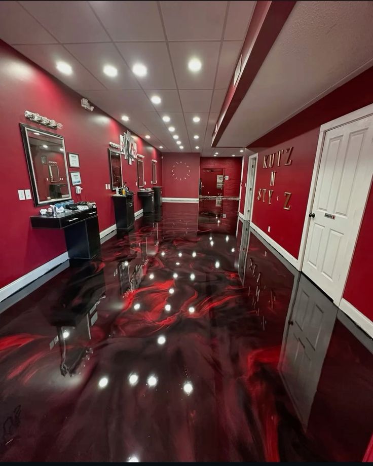 Projet sur mesure : salon au sol en résine époxy noir et rouge métallisé, finition miroir