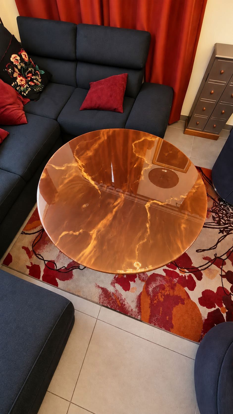 Table basse ronde en résine époxy cuivrée et translucide, finition brillante, dans un salon